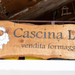 Asse di legno appesa all'ingresso del negozio a dogliani presso Cascina Lia